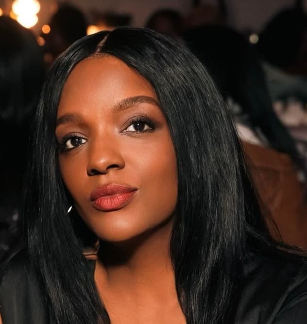 Close-up of a woman with long black hair, red lipstick, and dark eye makeup.